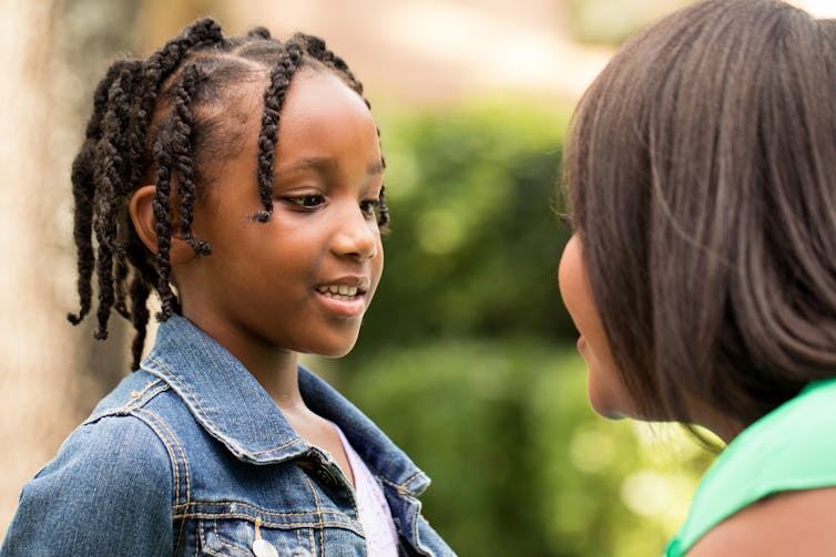 A child in discussion with an adult.