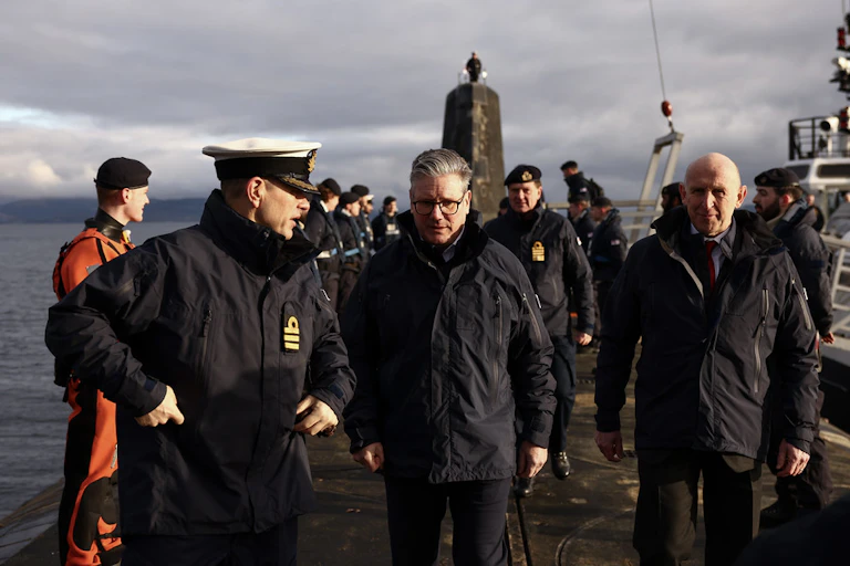 Keir Starmer standing on top of a submarine with naval officers.