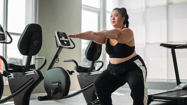 Woman in gym doing squats