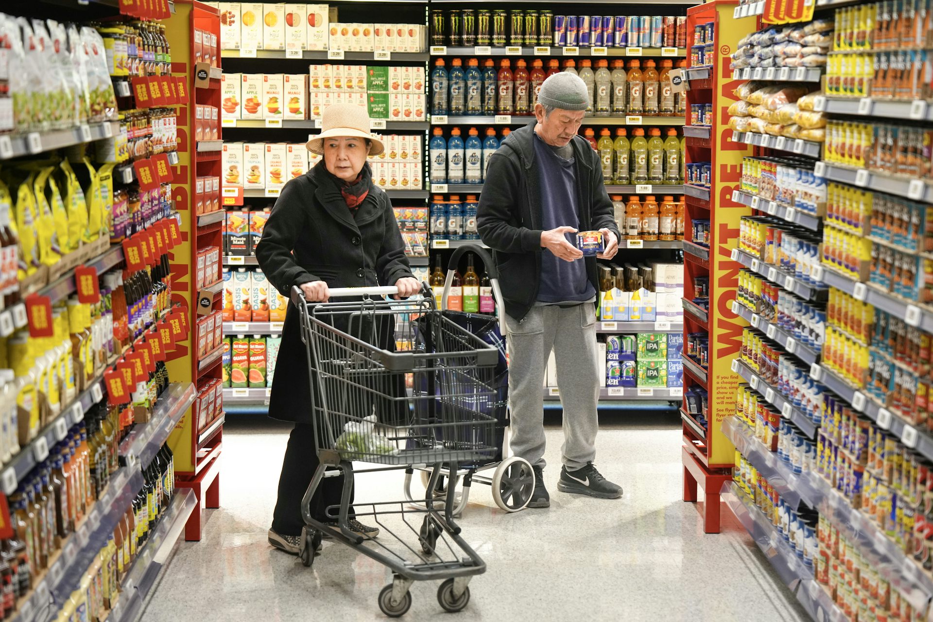 Two people browse a grocery store aisle