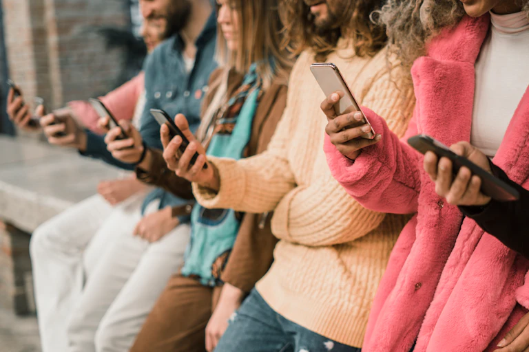 A row of people using smartphones