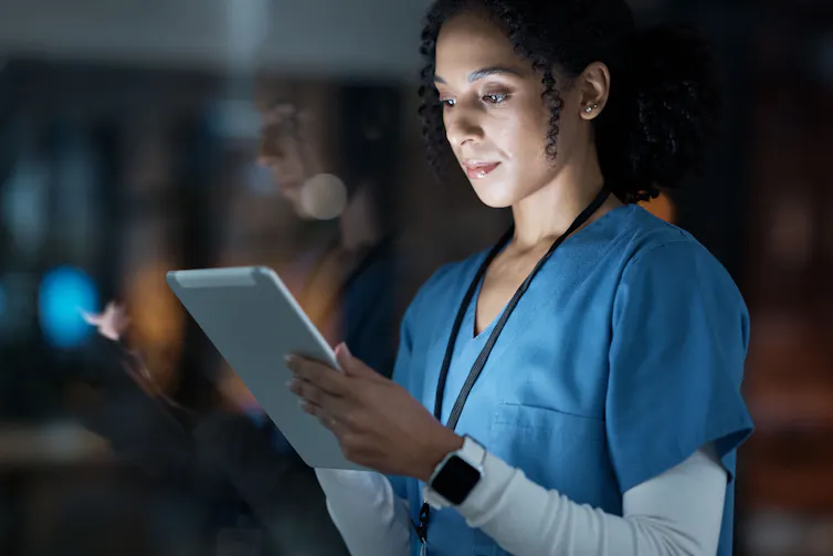 A doctor reading on a computer tablet.