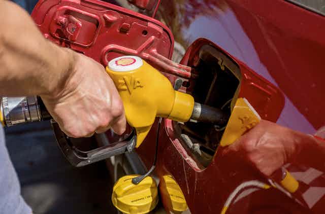 Person filling car up with fuel
