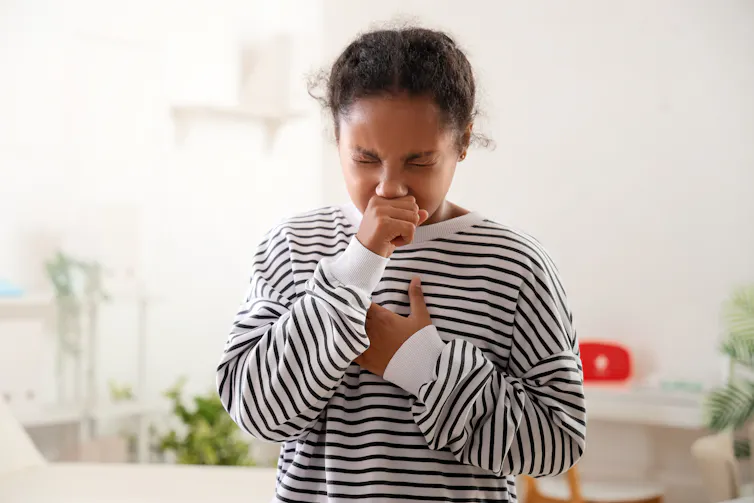 A young girl coughing