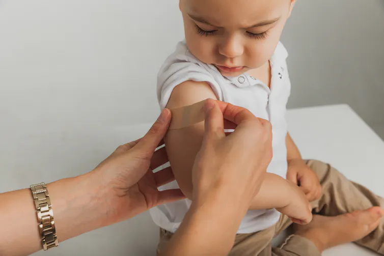 A child receives a bandaid after a vaccine.