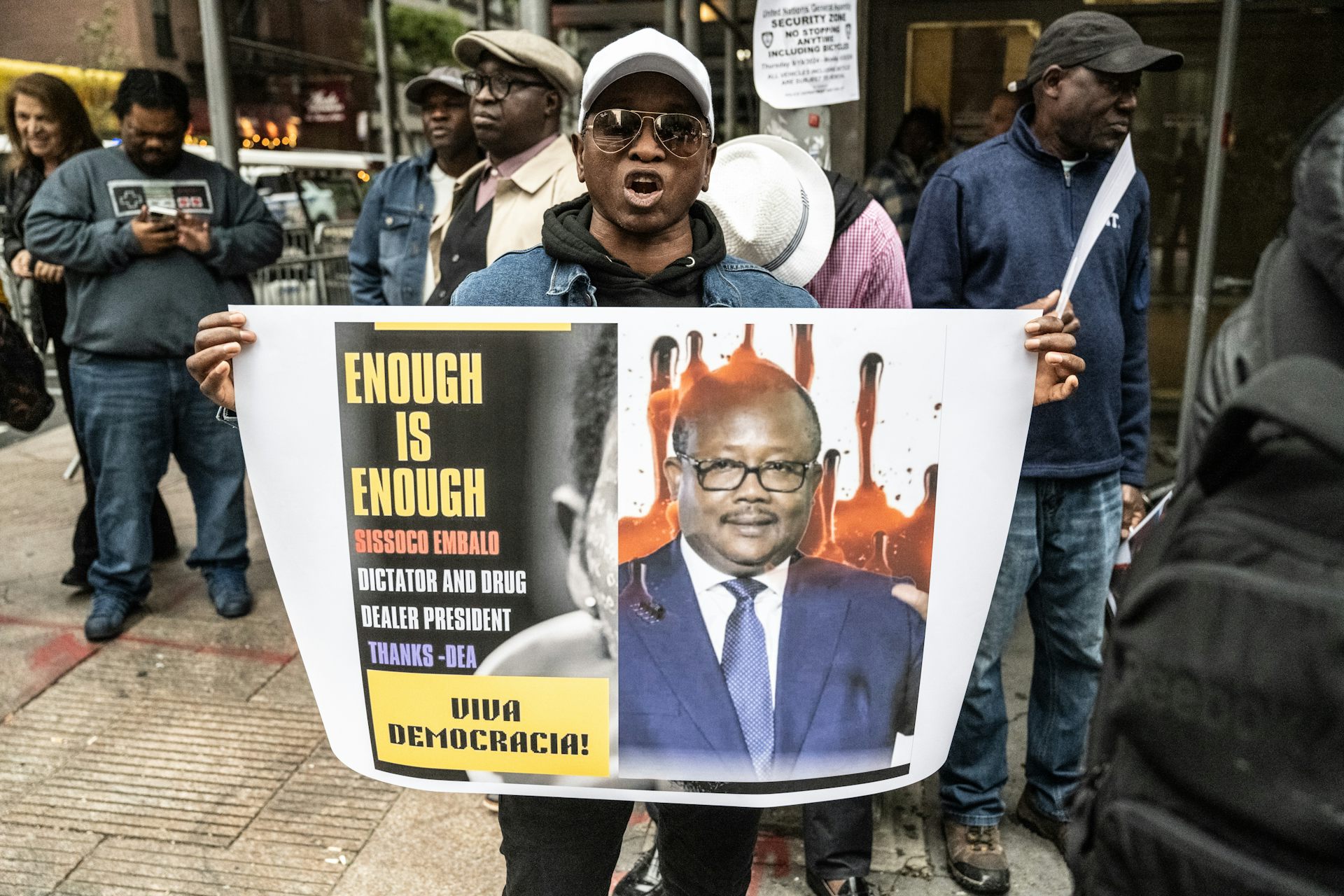 A man holds a placard with an image on it.