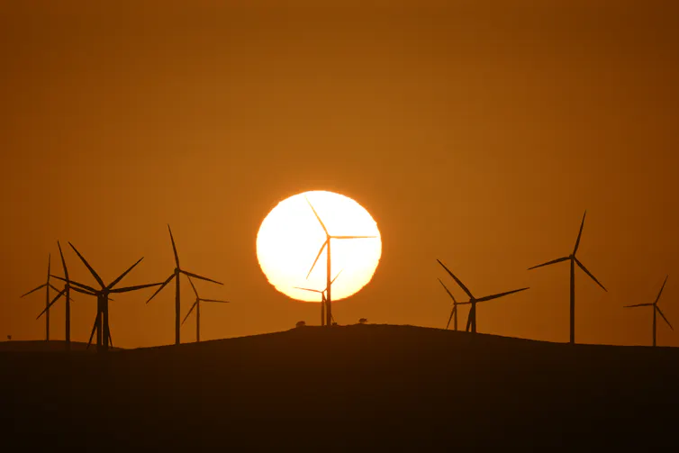 wind turbines against setting sun
