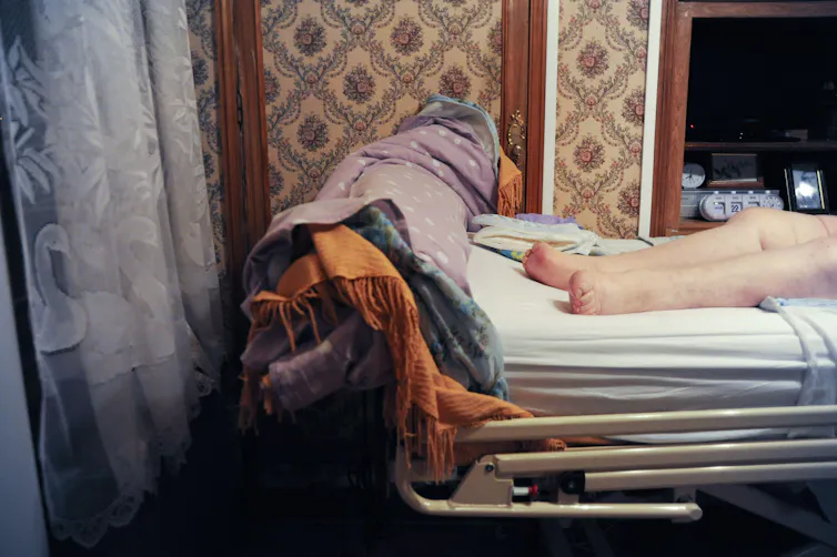 An elderly woman on a gantry at home.