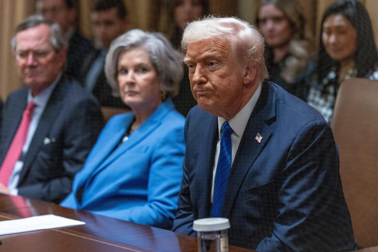 Donald Trump sits in the Cabinet Room of the White House next to his chief of staff Susie Wiles and surounded by aides.