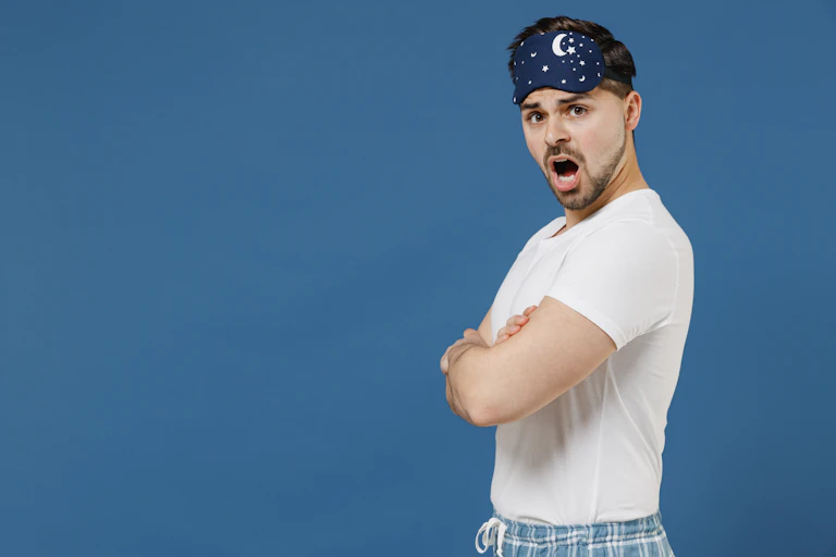 Side view of man wearing sleep mask looking shocked