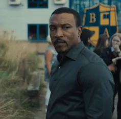 A man stares with a grim face.