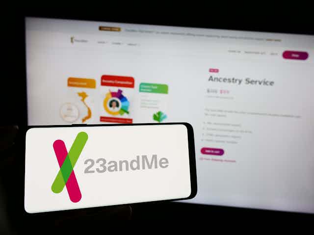 a computer screen and mobile phone screen both showing the 23andme logo and website