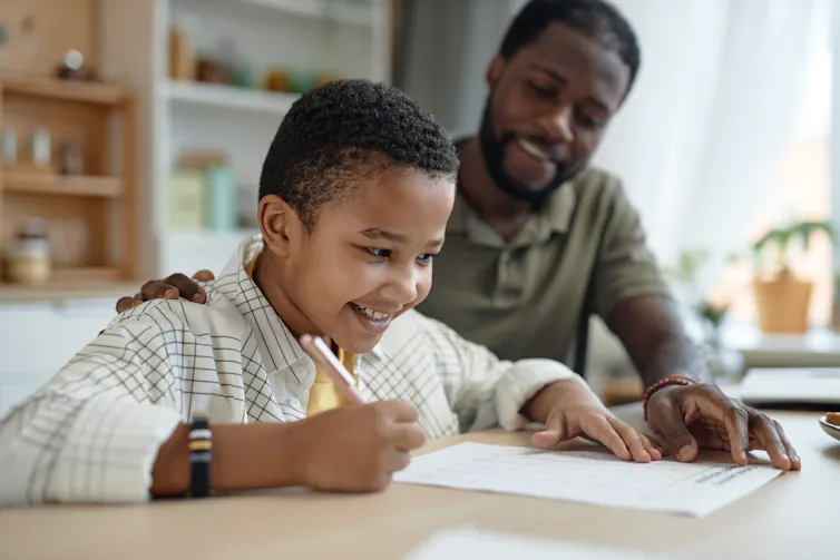 Man and son doing homework smiling