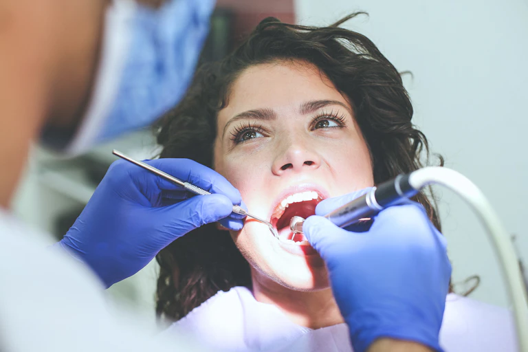 Une jeune femme se fait examiner les dents.