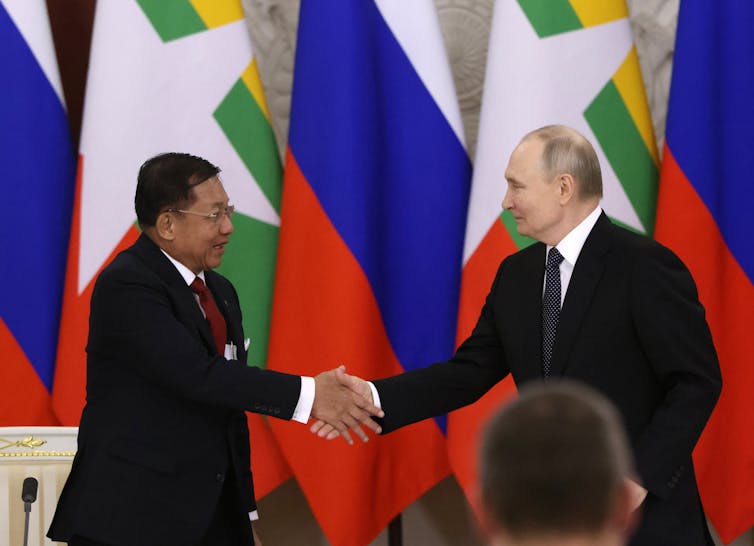 Two men in suits shake hands