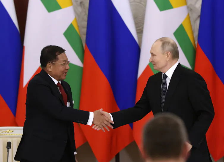 Two men in suits shake hands