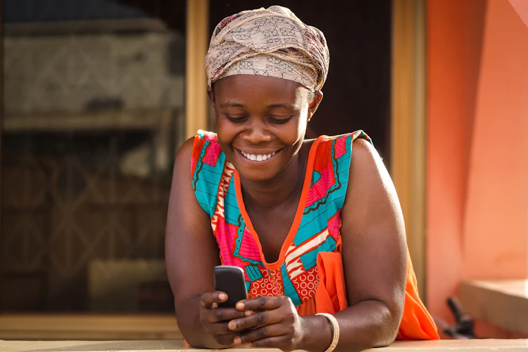 A smiling woman holding a phone.