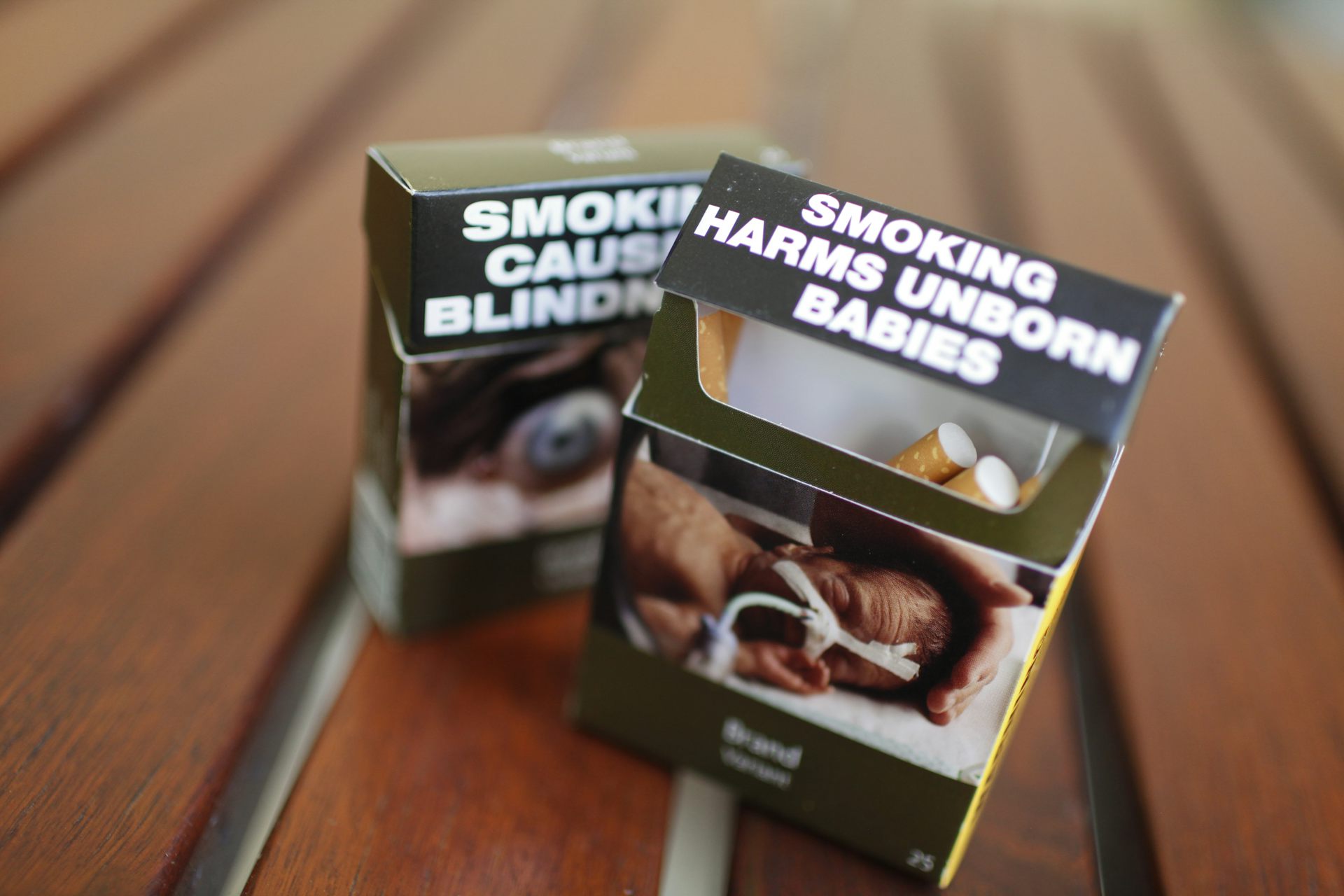 Two cigarette packs with plain packaging health warnings