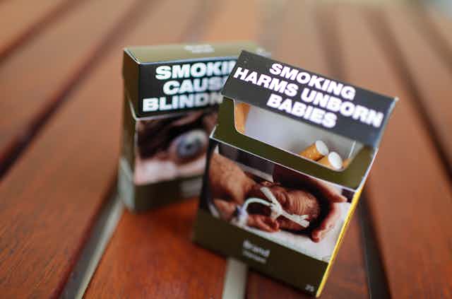 Two cigarette packs with plain packaging health warnings
