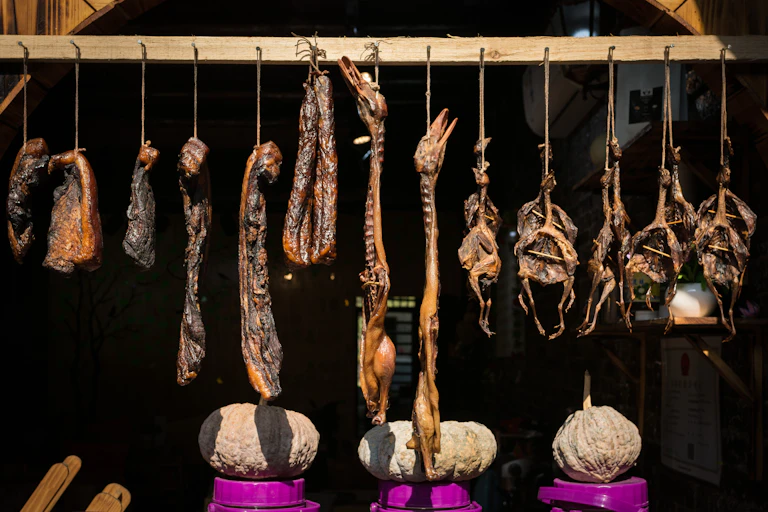 Pieces of dried meat and carcasses hanging in a row