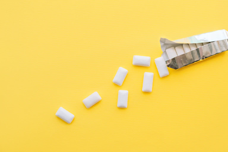 A pack of chewing gum spilling on a yellow background.