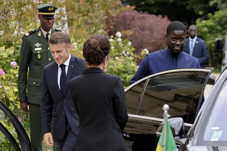 Emmanuel Macron and Bassirou Diomaye Faye exiting a car.