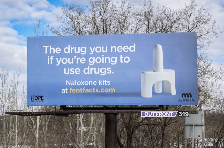 A billboard depicting a naloxone nasal spray device.