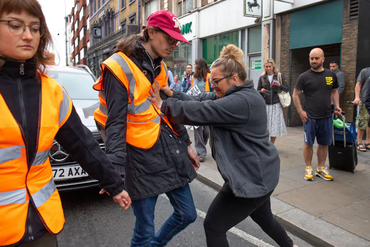 Woman shoves protester