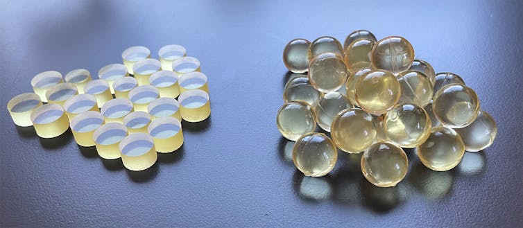Two piles of round objects. The objects on the left are flat disks, and the objects on the right are translucent spheres.