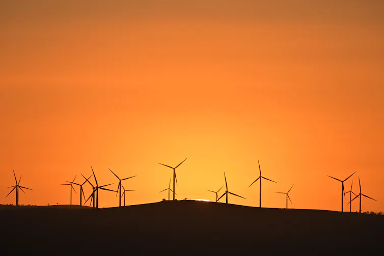 The sun rises over power-generating wind turbines at the Capital Wind Farm, 40km east of Canberra, Tuesday, March 18, 2025.