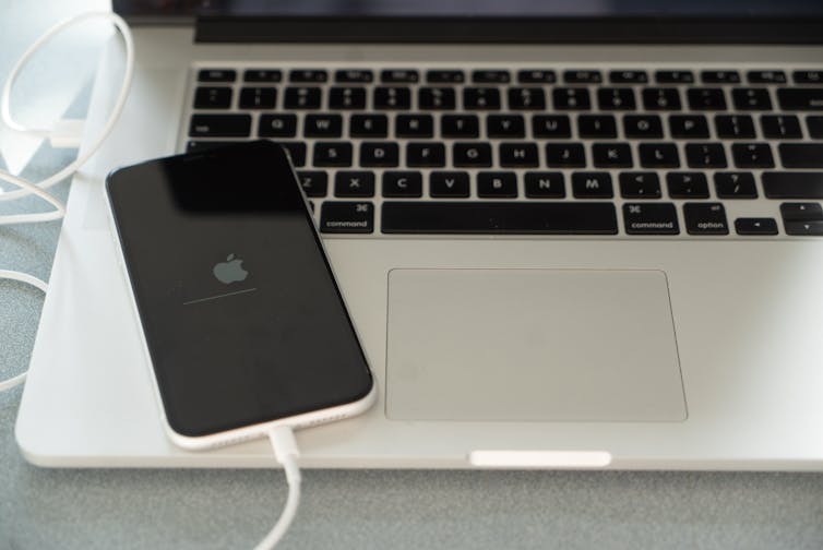An iPhone connected to a computer, with a restart screen.
