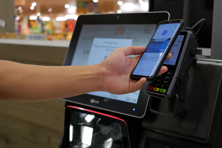 person pays for groceries at a self service checkout