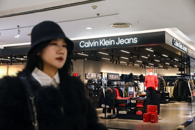 A Chinese woman in a hat outside a Calvin Klein store in Beijing.