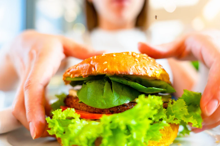 Close up of woman about to pick up a veggie burger