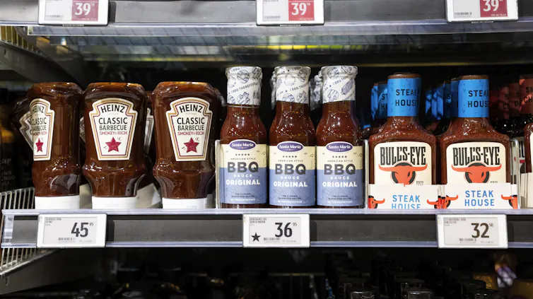 bottiglie di salsa sugli scaffali di un supermercato con la stella nera a indicare che il prodotto è europeo.