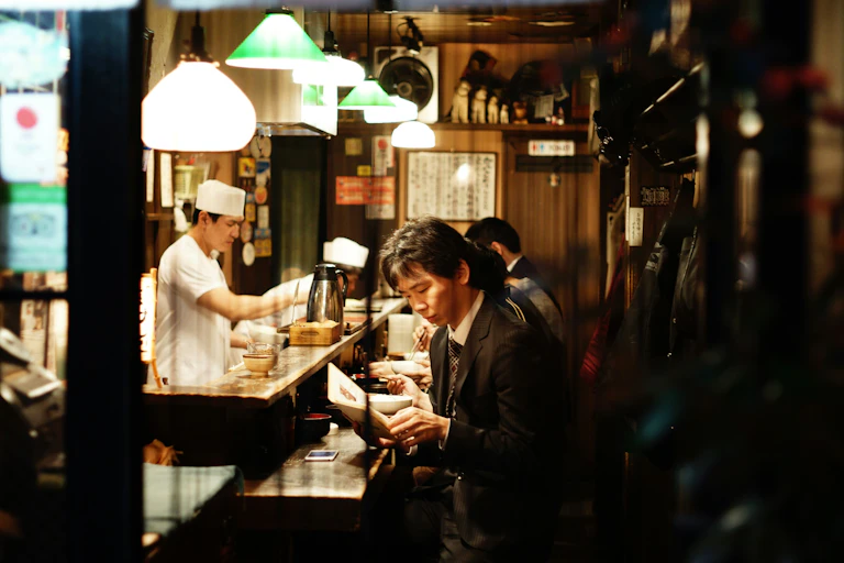 Un homme lisant un roman au comptoir d'un restaurant au Japon