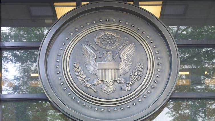Large medallion on window of building depicts eagle with ribbon in beak that reads: 'E pluribus unum'