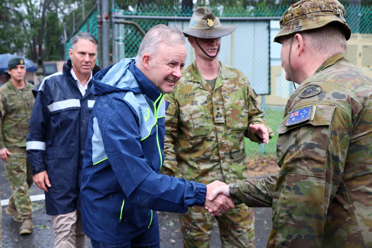 Anthony Albanese shakes the hand of a soldier in army uniform