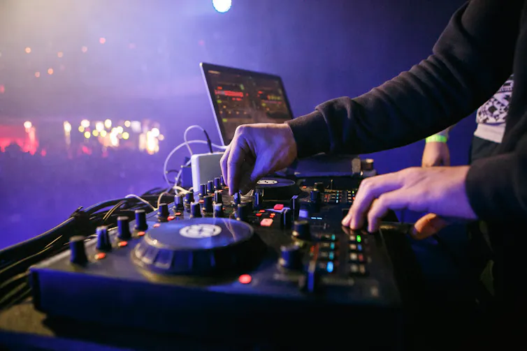 Close up of pair of hands mixing music on a DJ turntable