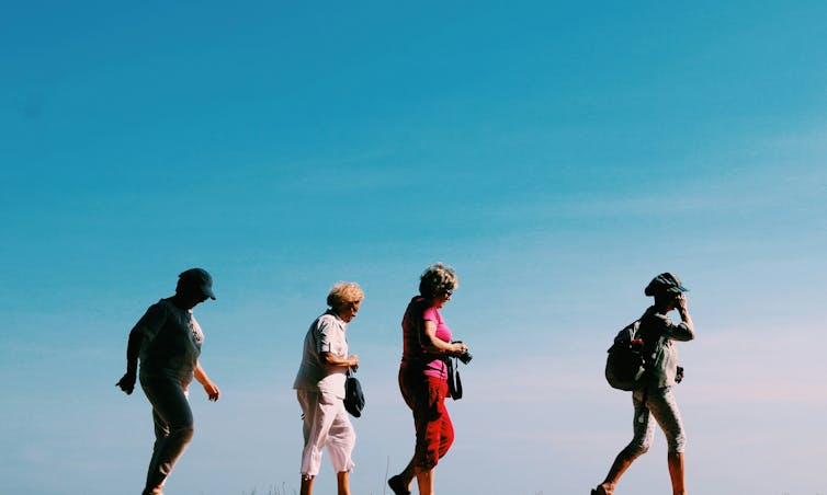 Four women walk across a horizon