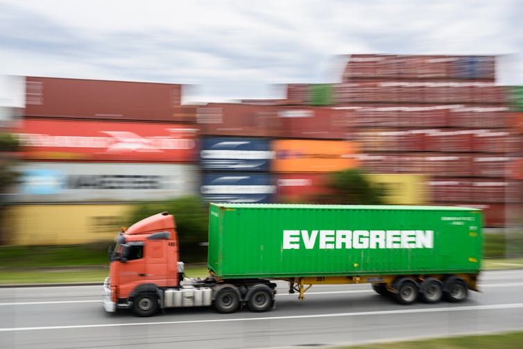 truck driving past cargo containers