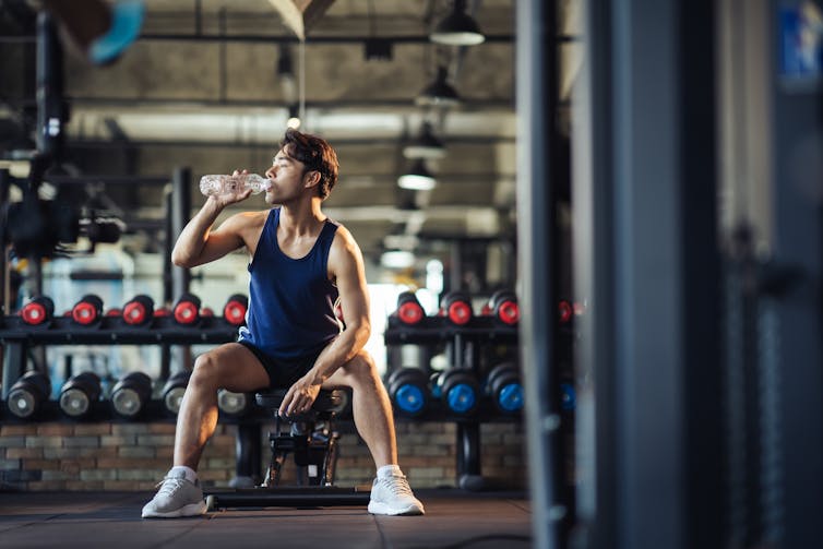 Man drinks water at the gym