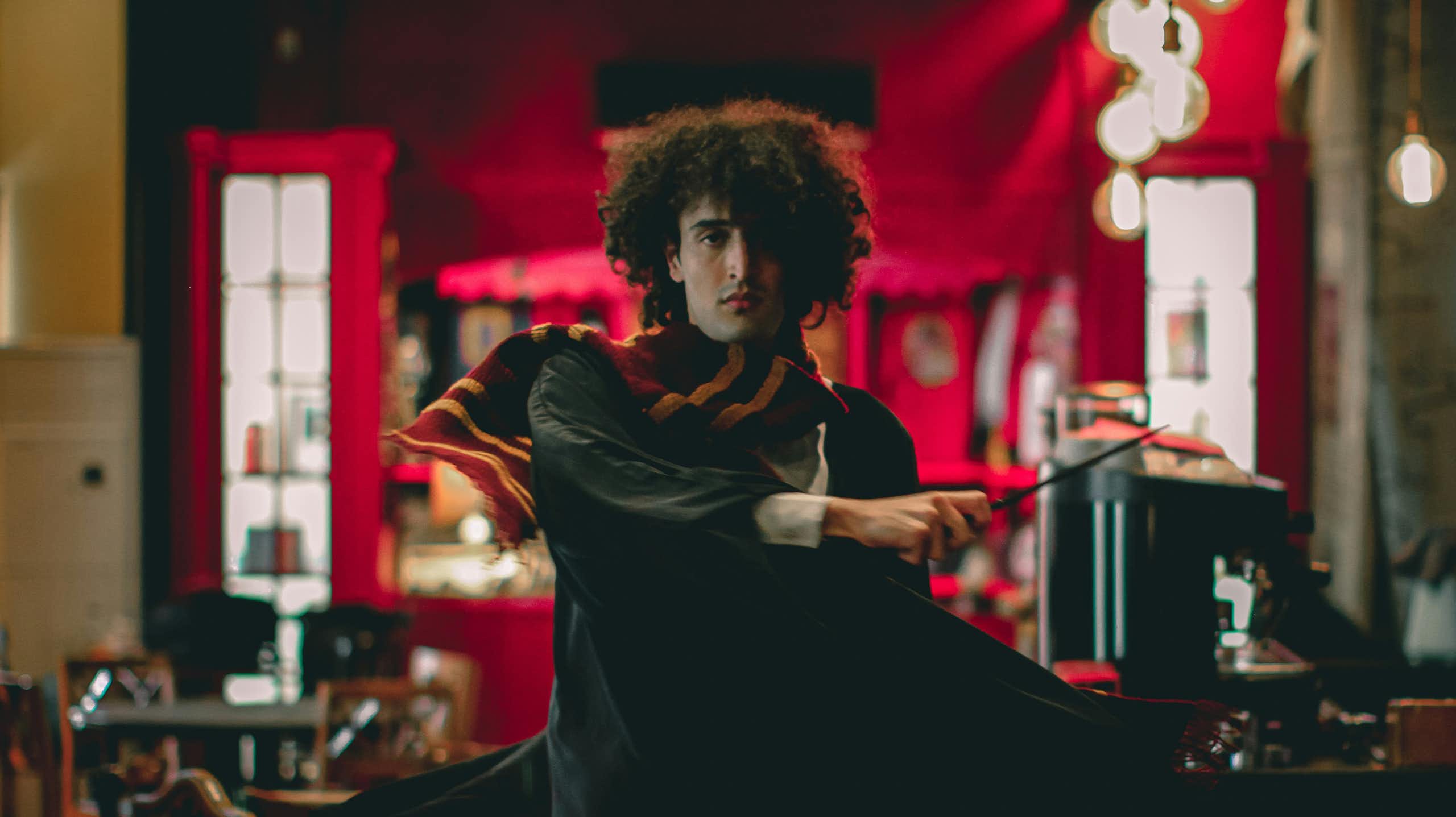 Un homme déguisé en sorcier tient une baguette magique.