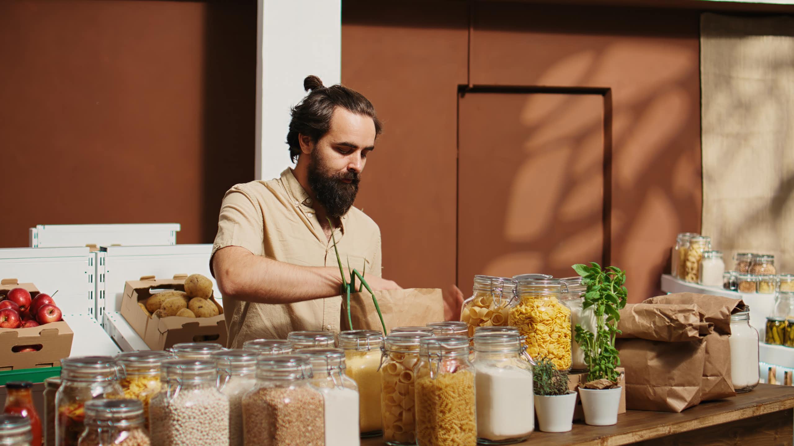 Homme remplissant ses bocaux de nourriture.