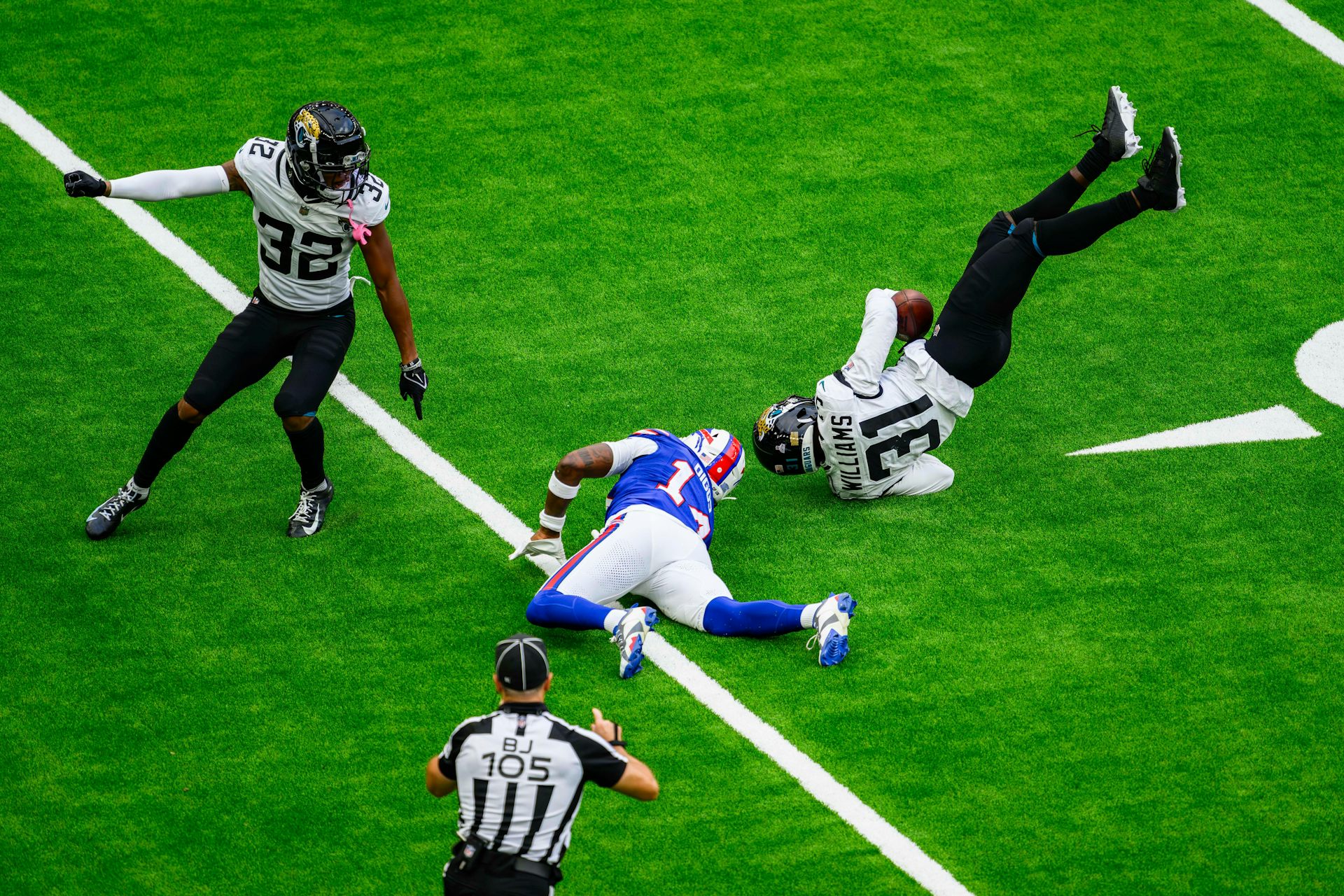 NFL players lying scattered on the turf.