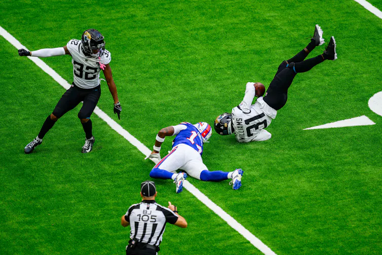 NFL players lying scattered on the turf.