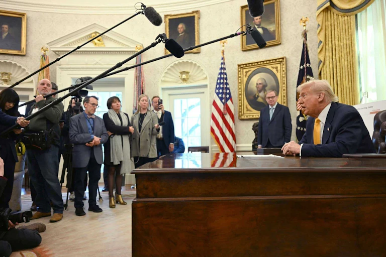 Donald Trump addresses member of the press in the Oval Office.