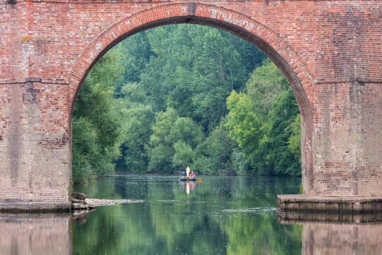 River, old bridge, dense vegetation in background