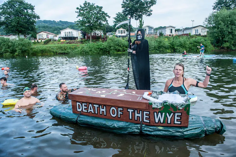 People swimming with grim reaper and coffin saying 'death of the wye'