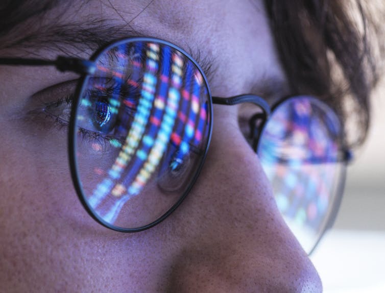 DNA sequencing results reflected off a person's glasses